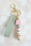 Sage Rainbow LOVE Wrist Strap Keychain – Pastel Cream Bokeh